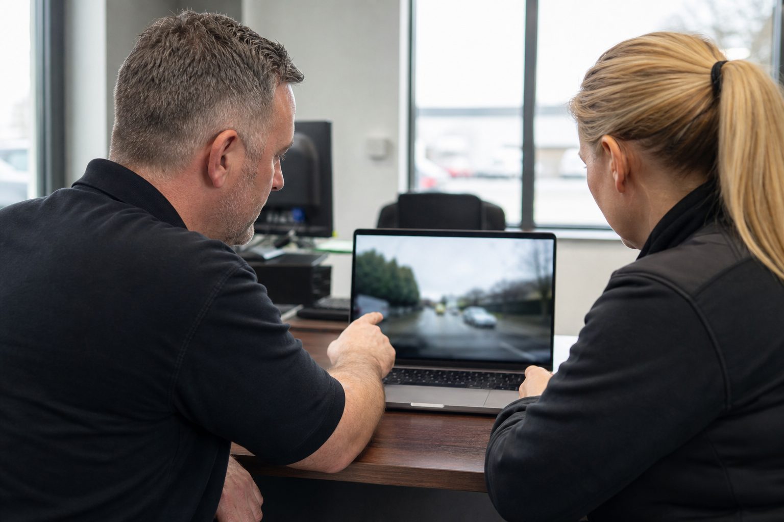 Reviewing vehicle camera footage on a laptop for driver coaching